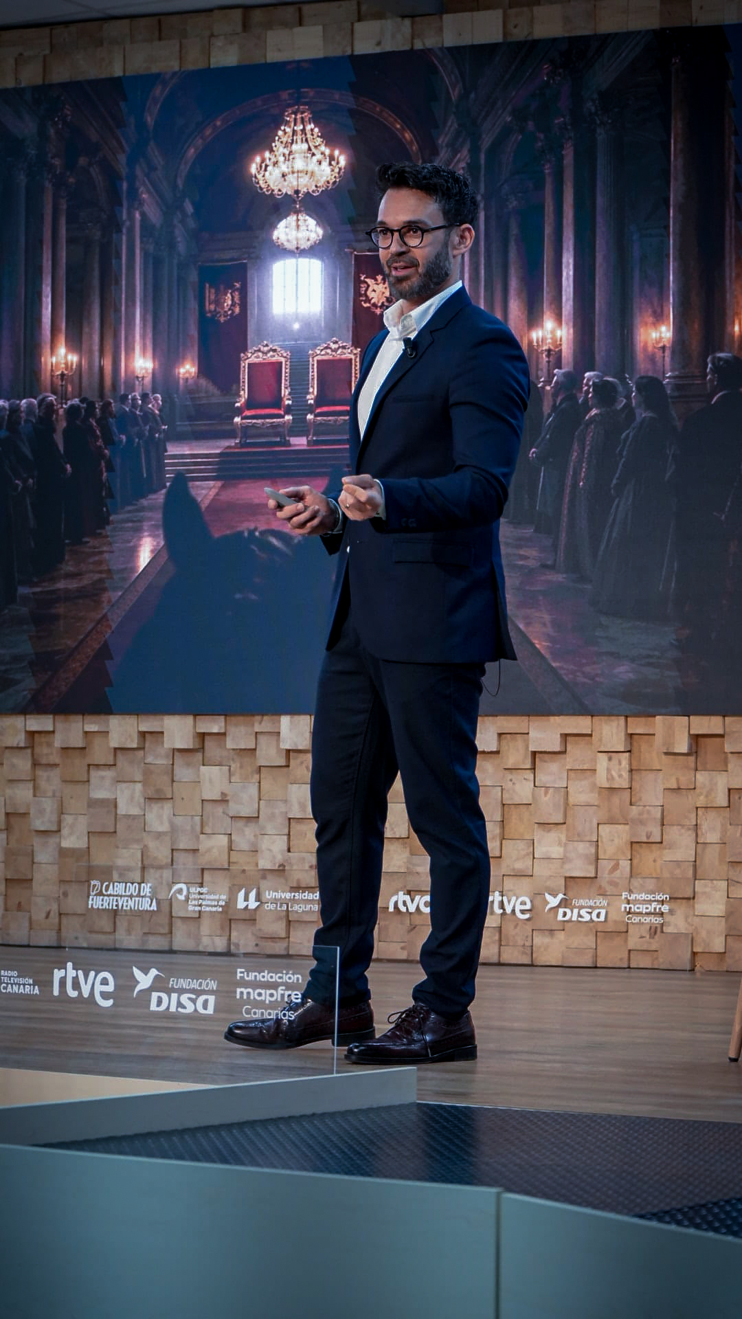Alberto Ávila en el escenario con la imagen del Palacio al fondo